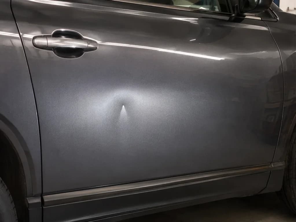 Panel with paint-intact dent before PDR